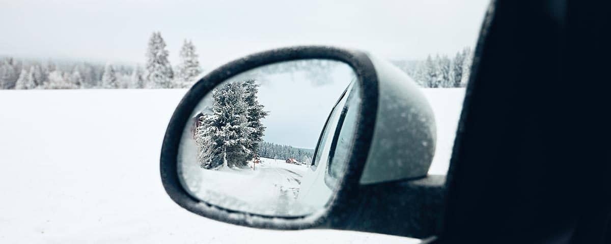 Look into a side view mirror with snow
