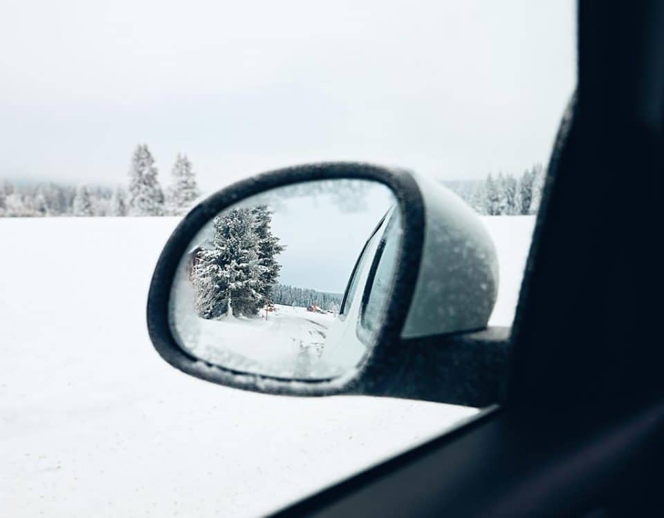 Look into a side view mirror with snow